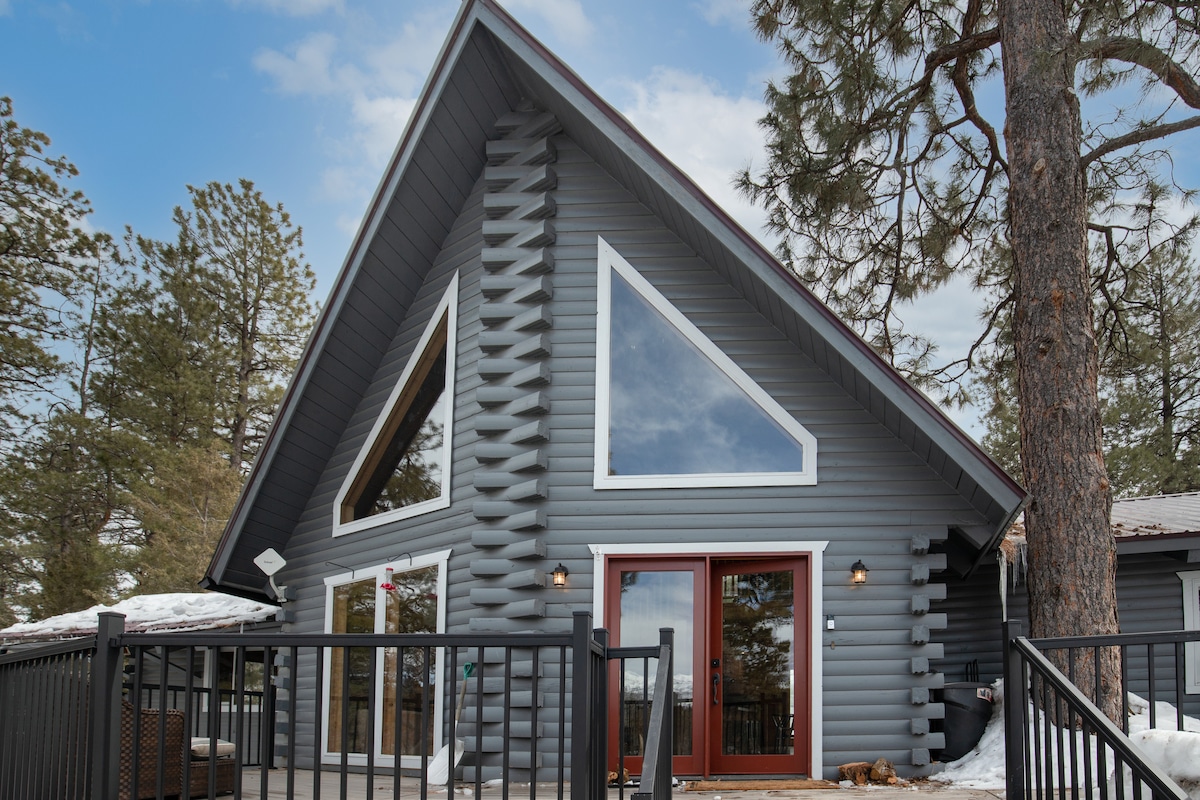 A-frame cabin exterior with a red door in winter at Wildcat Cabin