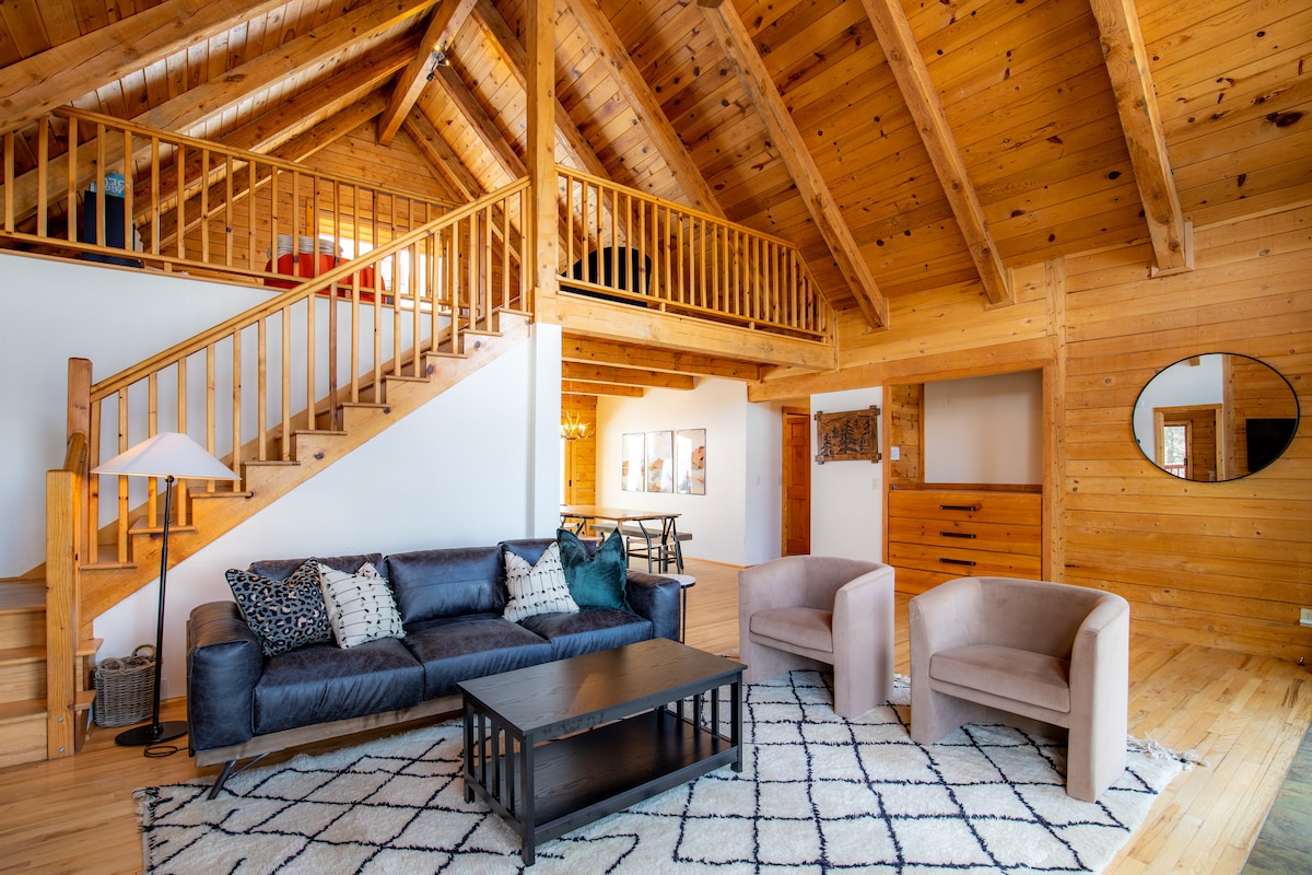 Wide living room view with the loft staircase at Wildcat Cabin
