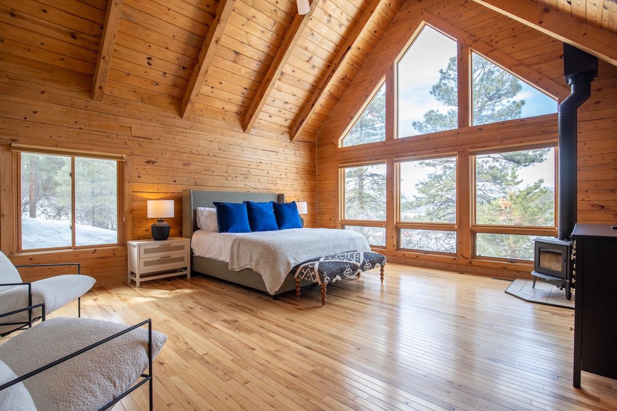 King suite with vaulted ceiling, wood-burning stove, and huge picture windows at Wildcat Cabin